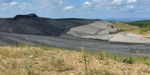 Active construction of a coal waste pile with a comprehensive mine drainage control and prevention system consisting of a clean water underdrain, acid drainage leachate collection system, alkaline addition, and synthetic liner and capping system. coal-waste-pile